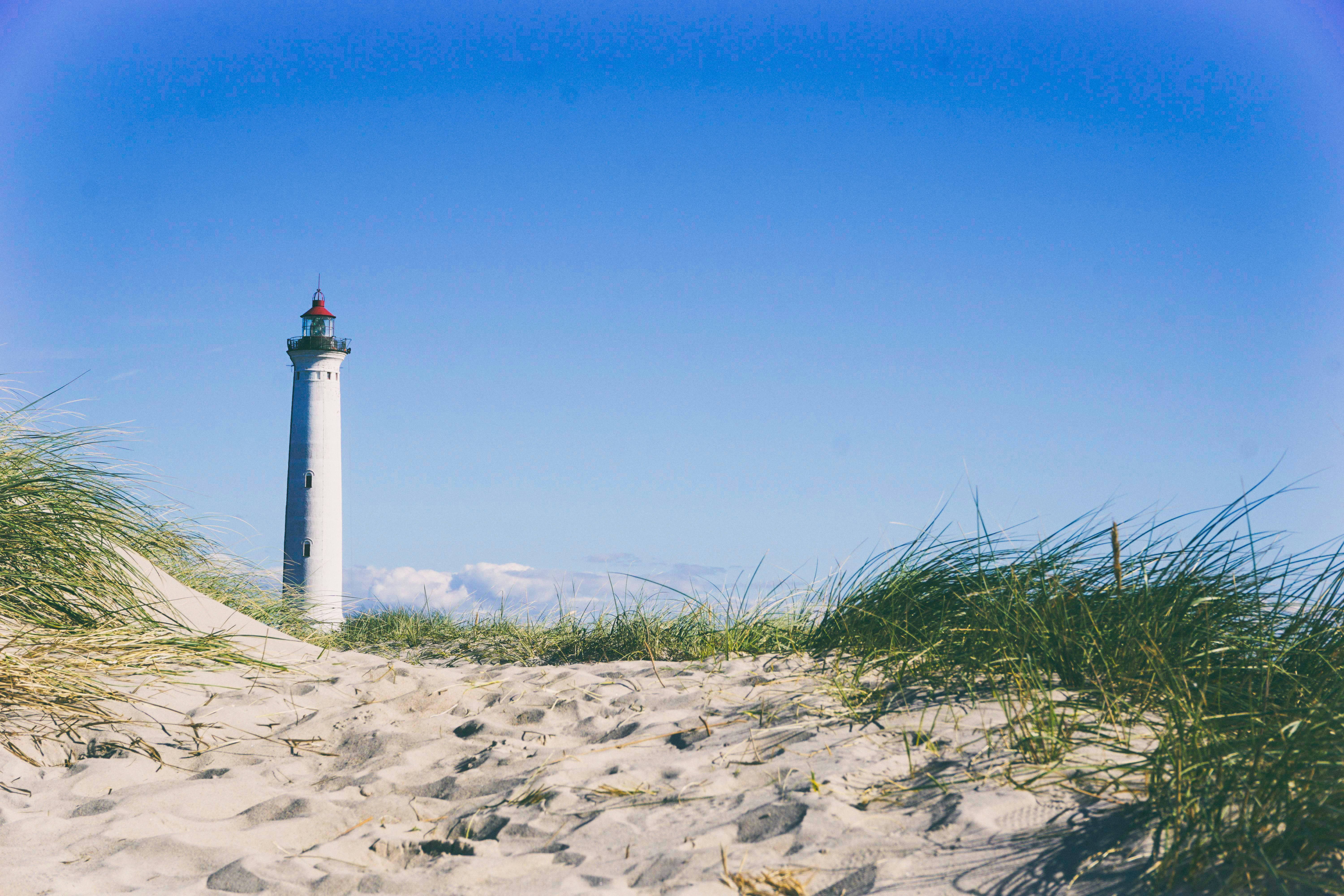 white lighthouse surrounding grass